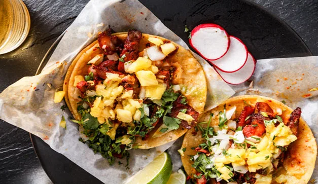 ¿Por qué los tacos al pastor llevan piña? Descubre el verdadero origen de esta combinación y las teorías que explican por qué este ingrediente se volvió indispensable.